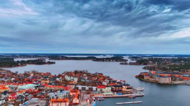 Suyun üzerindeki güzel şehir manzarasının görüntüsü. Stockholm takımadalarının geçidi olarak bilinen Vaxholm üzerindeki dramatik bulutlar gökyüzünü kaplıyor..