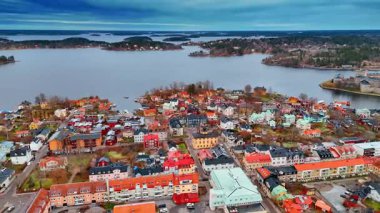 İsveç 'in Vaxholm şehrindeki alçak renkli güzel binalar. Arka planda Malar Gölü 'nün gri su manzarasında birden fazla ada var..