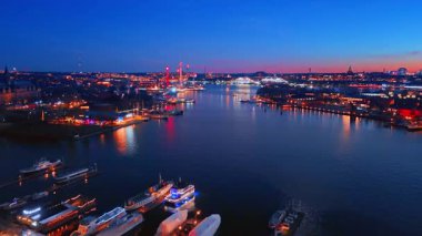 Renkli şehir ışıkları geceleri su manzarasına yansıyor. Stockholm, İsveç 'teki gölün üzerindeki İHA görüntüleri..