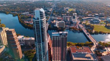 Austin, ABD, 21 Kasım 2025: Colorado Nehri 'nin rıhtımındaki yüksek binalar. İnsansız hava aracından Austin, Teksas 'ın geniş yeşil manzarasına hava perspektifi.