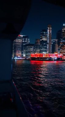 New York, ABD 'nin güzel, parlak bir rıhtımını tekneden çekiyoruz. Rıhtımdaki iskele 17 'nin renkli ışıklarıyla aradaki mesafe. Dikey video.