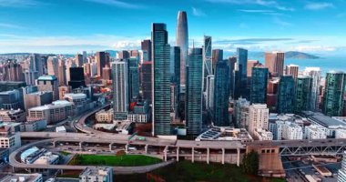 Canlı metropolün modern cam kulelerine gidiyoruz. Çok katlı otoyollarda birden fazla araba hareket ediyor. San Francisco, California, ABD hava manzaralı.