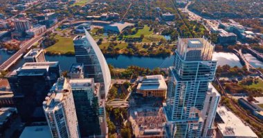 Austin, Teksas, ABD 'nin modern şehir merkezindeki gökdelenlerin üzerinden geçiyor. Colorado Nehri 'nin rıhtımına yaklaşıyoruz..