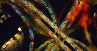 Yüzlerce araba çok katlı otoyollarda hareket ediyor. Geceleri şehirde gezip tozmak. Los Angeles, Kaliforniya, ABD.