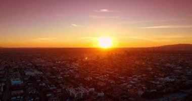Güzel batan güneş büyük bir şehrin manzarasını aydınlatıyor. Günbatımı Los Angeles, Kaliforniya, ABD 'de. Hava görünümü.