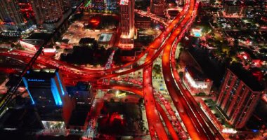 Miami, ABD, 4 Ağustos 2025: Otobanlarla çok katlı kavşak geceleri kırmızı yanıyor. Çok sayıda araba yoğun trafikte yollar boyunca hareket ediyor. Miami, Florida 'nın gece hayatı, ABD.