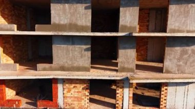 Tamamlanmamış tuğla binanın zemininde uçmak. İşteki birkaç projeli inşaat sahası.