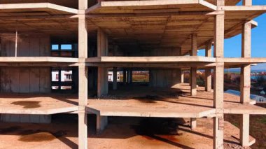 Gelecekteki binanın zemininde yükselin. Güneşli bir günde İHA görüntülerinden terk edilmiş inşaat alanı.