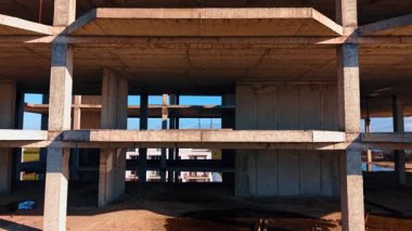 Çok katlı binanın zeminine iniyor. İnşaat alanında büyük beton yapı..