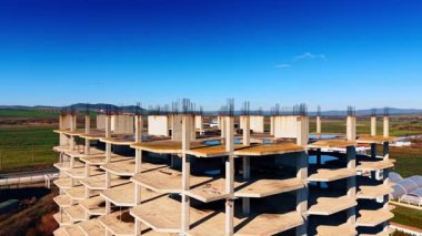 Tamamlanmamış binanın tepesinde metal demiri ile uçmak. İnşaat alanındaki çok katlı silindire yaklaşıyoruz..