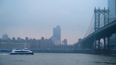 New York, ABD, 24 Aralık 2025 Doğu Nehri üzerindeki Manhattan Köprüsü. New York 'ta sisli bir kış gününde Brooklyn limanından Manhattan Köprüsü manzarası.