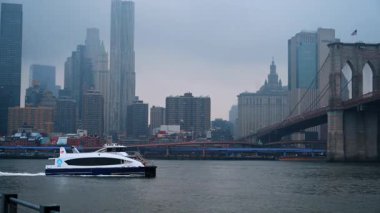 New York, ABD, 24 Aralık 2025 Brooklyn Köprüsü ve NYC feribot kışı. New York feribotu kışın Manhattan Köprüsü 'nden geçiyor..