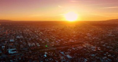 Güneşin batışı Los Angeles, Kaliforniya, ABD 'nin manzarasını kamaştırıyor. Şehrin yukarısındaki insansız hava aracı görüntüleri hareketli kavşağa yaklaşıyor..