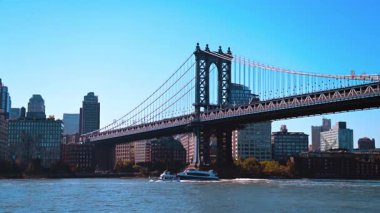 Manhattan Köprüsü 'nden uzaklaşan iki tekne nehir kıyısında hareket ediyor. Rıhtımdaki New York silueti.