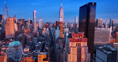 New York, ABD, 24 Aralık 2025: New York 'un uzun düz caddesinde arabalar ile dolu bir şekilde yüksekten uçmak. New Yorker Oteli, One Penn Plaza, Empire State Binası 'na yaklaşıyoruz..
