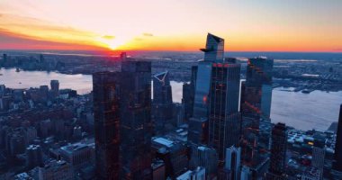 Doğu Nehri 'nin rıhtımında duran yüksek camlı bir grup. Günbatımında New York 'un engin manzarasının üzerinde güzel turuncu gökyüzü. Hava görünümü.