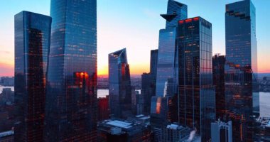 Gün batımında cam gökdelenlerin ışıkları yandı. New York 'un muhteşem kuleleri batan güneşle renklenen gökyüzüne karşı.