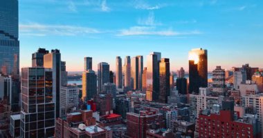 New York, ABD, 24 Aralık 2025: New York 'un cam gökdelenleri batan güneşi yansıtıyor. İnsansız hava aracı görüntüleri Metropolis 'in manzarasına iniyor..
