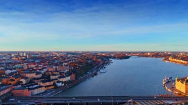İsveç 'in Stockholm şehrinden geçen nehir manzaralı bir uçuş. Gün batımı renkleri Bir şehrin manzarası.
