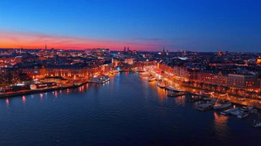 Yatlar ve tekneler Stockholm, İsveç 'in iyi aydınlatılmış rıhtımlarında duruyor. İHA 'dan şehrin güzel manzarası.