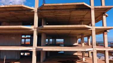 Birkaç katlı bina yapım aşamasında. İnsansız hava aracı gelecekteki binanın iskeleti boyunca iniyor..