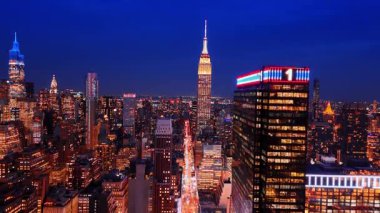 Trafiğin yoğun olduğu düz yolda ilerliyoruz. Merkezinde Empire State Binası bulunan Manhattan, New York, ABD 'nin gece panoramasını gözler önüne seriyor.