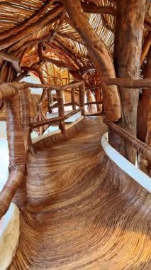 Dalgalı koridorda ahşap korkuluklarla yürü. Azulik Otel Kompleksi 'ndeki SFER IK Sanat Müzesi' nde tur. Tulum, Meksika. Dikey video.