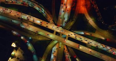 Çok katlı kavşakta gece trafiği. Otoyollarda farları yanan arabalar. Üst görünüm.