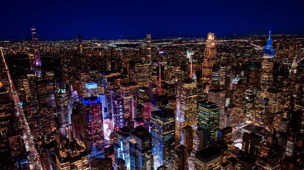 Gece yarısı Manhattan 'ın göbeğinde. Manhattan şehir merkezinin yüksek irtifa gece anteninde aydınlık gökdelenler