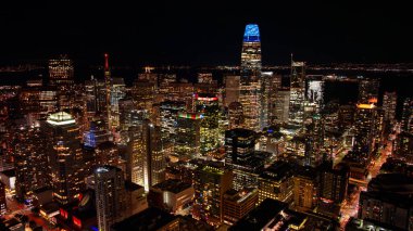 Geceleri San Francisco 'nun göbeğinde. San Francisco şehir merkezinin yoğun gökdelenleri ve parlayan sokaklarıyla gece hava görüntüsü..