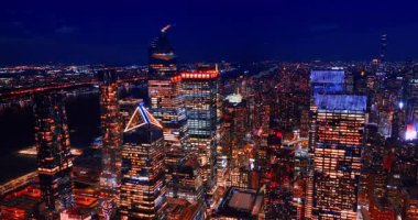 Karanlık deniz kıyısındaki aydınlık gökdelenlerin üzerinden geçerek. New York, ABD 'nin gece manzarası.