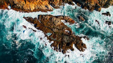 Big Sur California 'nın Rocky kıyı şeridi. Güçlü okyanus dalgalarıyla kaplı engebeli Big Sur kıyı şeridinin havadan görünüşü.