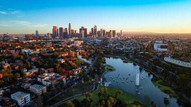 Gün batımında Los Angeles siluetiyle Echo Park Gölü. Gemiler ve merkez çeşme Echo Park Gölü 'nde otururken şehrin silueti arkamızda parlıyor..