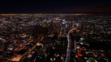Geceleri Los Angeles 'ın göbeğinde. Karanlık çöktükten sonra DTLA kulelerini çevreleyen parlak şehir ışıkları ve trafik akıntıları.