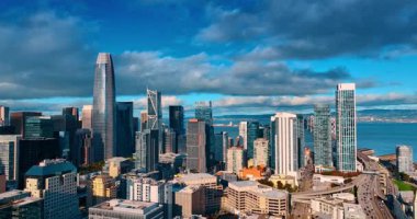 San Francisco, Kaliforniya 'nın görkemli gökdelenleri bulutlu gökyüzü ve mavi deniz manzarasına karşı. Şehir merkezinde insansız hava aracının modern mimarisi ile güzel..