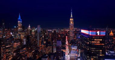 Muhteşem Manhattan, geceleri göz kamaştırıcı aydınlatma. Empire State Binası 'nın tepesinde koyu mavi gökyüzü parıldıyor. New York, ABD 'nin hafif caddesine inin..