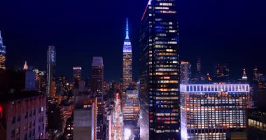 Gece vakti Manhattan 'ı geçen aydınlık caddede yükseliyor. Muhteşem Empire State Binası 'nın neon kapaklı görüntüsü. New York, ABD.