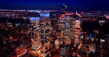 Pencereleri açık olan gökdelenlere yaklaşıyoruz. New York, ABD 'nin gece panoraması.