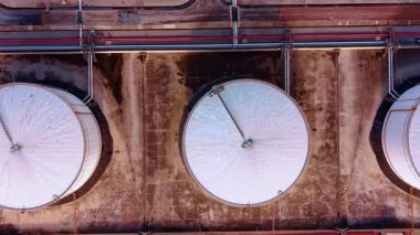 Yakıt depolamak için büyük ve küçük tanklar. Petrol rafinerisindeki siloları birbirine bağlayan birden fazla boru hattı var. Üst görünüm.