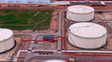 Modern fabrikada petrol depolamak için geniş yuvarlak tanklar. Boru hatları sistemi siloları birbirine bağlıyor. Hava görünümü.