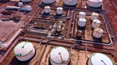 Rafineri petrol fabrikasının üzerinde yavaşça uçuyor. Depolama yakıtı tanklarını birbirine bağlayan sayısız boru hattı var..