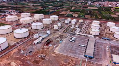 Petrol depolamak için çok sayıda tankı olan rafineri fabrikasının sanayi bölgesi. Tanker kamyonu benzin istasyonuna gidiyor. Hava görünümü.