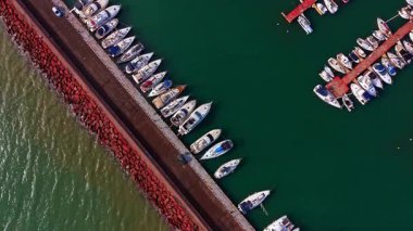 Liman boyunca yolu olan baraj. Deniz yeşili sularda sayısız gemi var. Üst görünüm.