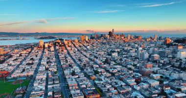 Batan güneş, San Francisco, California, ABD şehir merkezindeki gökdelenleri aydınlatıyor. İnsansız hava aracından metropolün yoğun şehir manzarası.