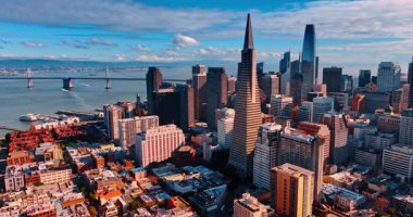 San Francisco, ABD, 9 Ocak 2026, San Francisco şehir merkezi körfezin rıhtımında. Oakland Bay Köprüsü ve gökyüzü arkaplanda bulutlarla görünüyor. Hava perspektifi.