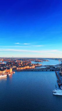 Stockholm, İsveç 'te nehrin üzerindeki görüntüler. Güneşli bir günde şehrin tarihi kısmı. Dikey video.
