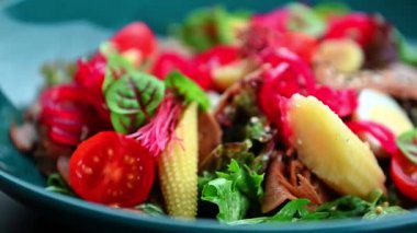 Sebze, yumurta ve yeşil sebzeli canlı bir salata. Bir kasede taze sebzeler, yeşiller, yumurtalar ve renkli malzemeler bulunur..