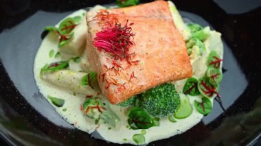 Akşam yemeğinde bir restoranda servis edilen brokoli ve soslu somon yemeği. Yemek sırasında brokoli ve sos dolu bir yatakta ızgara somon balığı..