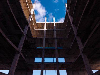 Bitmemiş otelin beton avlusu. Bitmemiş otelin içinde açık avlu alanı katmanlı beton zemin ve gökyüzünü gösteriyor..