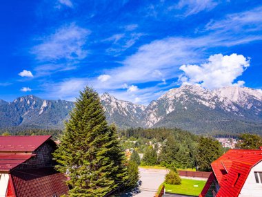 Karpatlar 'daki dağ köyü. Mavi gökyüzünün altındaki Karpat Dağları 'nın eteklerinde küçük bir yerleşim yeri var..